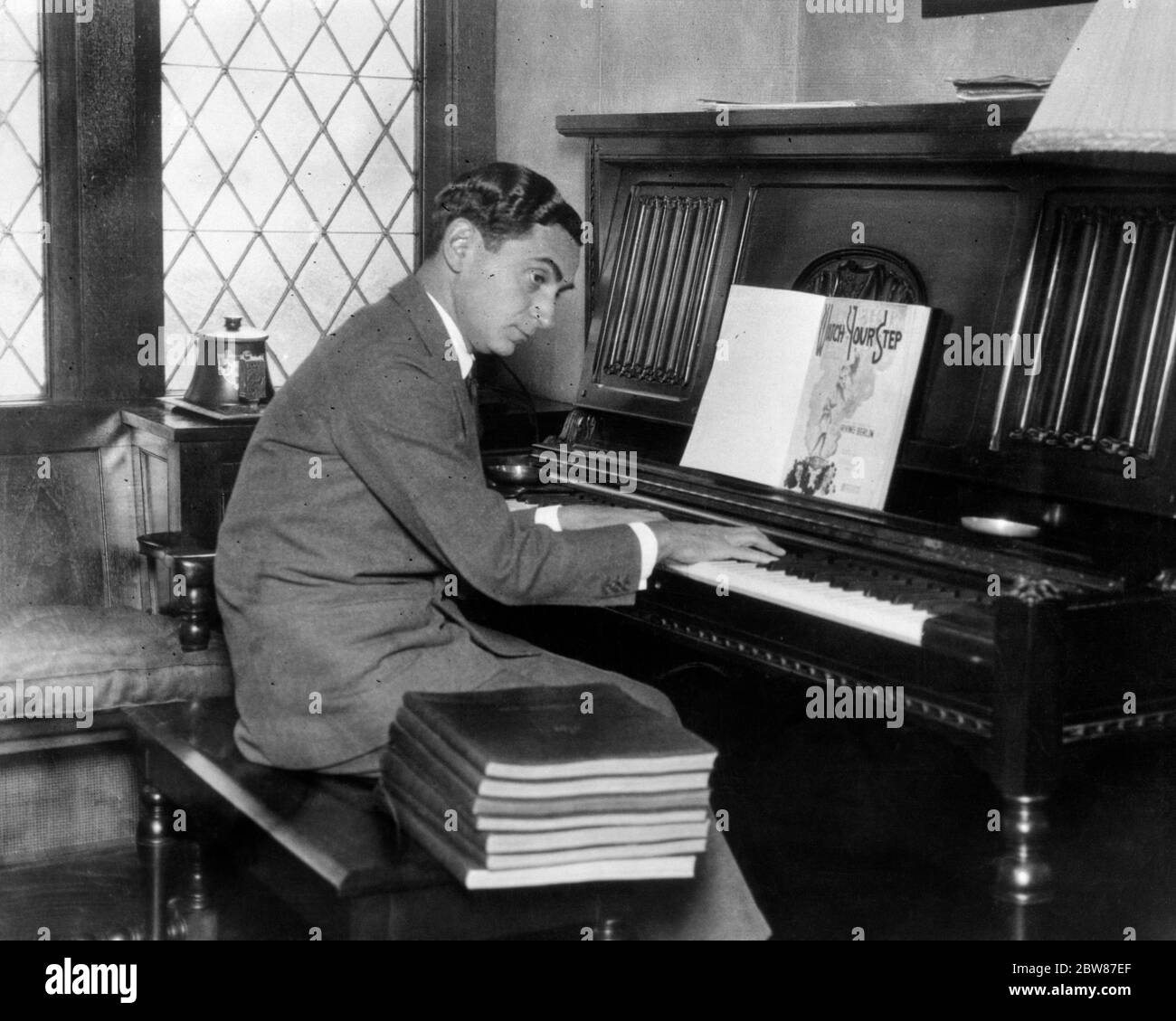 1910s 1920s TIN PAN ALLEY COMPOSER IRVING BERLIN AT PIANO KEYBOARD LOOKING AT SHEET MUSIC FOR HIS DEBUT MUSICAL WATCH YOUR STEP - asp fwp1945 ASP001 HARS CONFIDENCE B&W SUCCESS PERFORMING ARTS HAPPINESS BERLIN HIS KNOWLEDGE LEADERSHIP INNOVATION PRIDE AT AUTHORITY OCCUPATIONS COMPOSER CONCEPTUAL STYLISH CREATIVITY DEBUT MID-ADULT MID-ADULT MAN BLACK AND WHITE CAUCASIAN ETHNICITY HANDS ONLY IRVING OLD FASHIONED Stock Photo