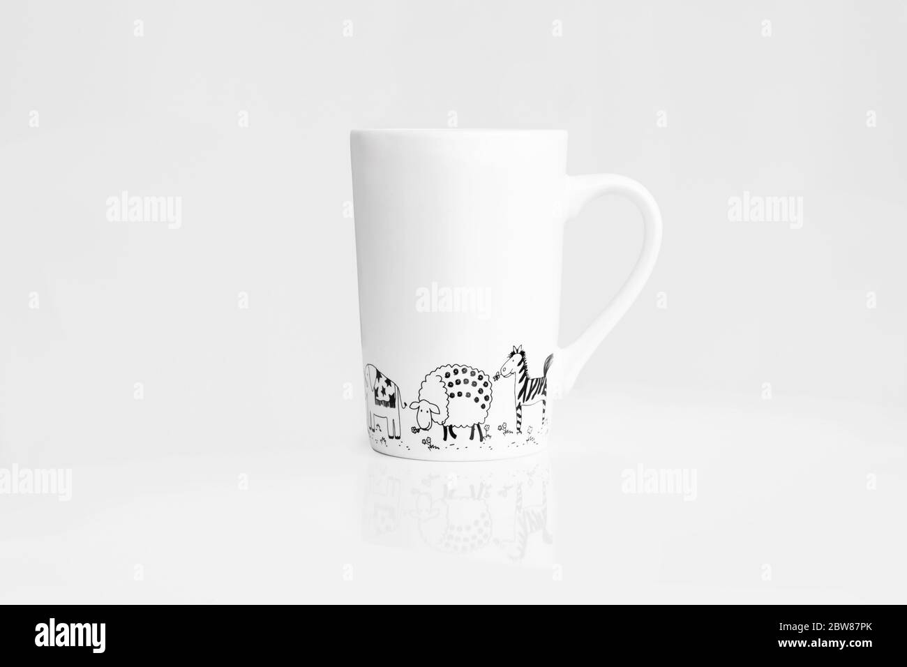 White tea cup painted with animals on white background Stock Photo