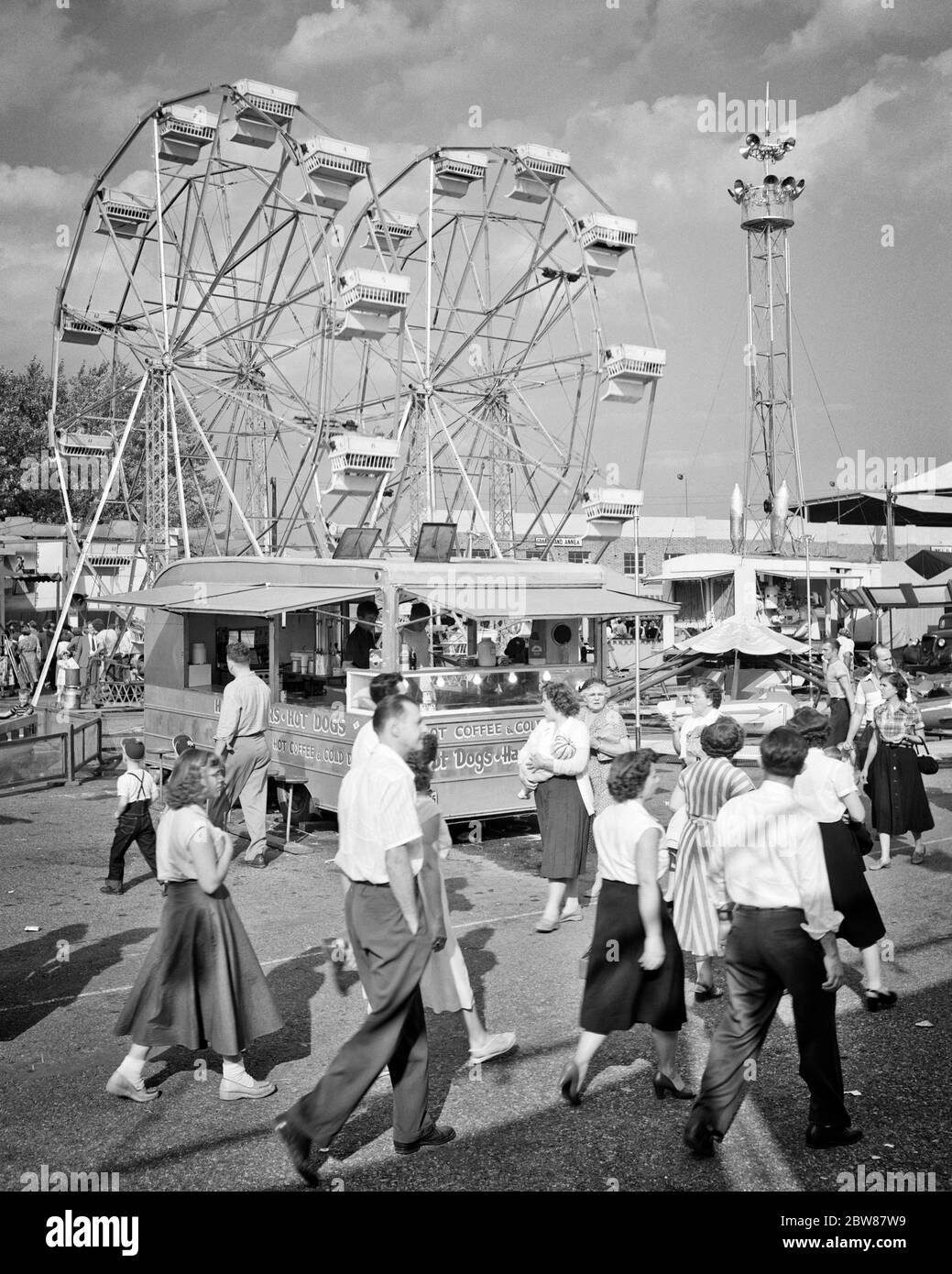 1950s CROWD MEN WOMEN TEENAGERS ATTENDING WALKING ON THE MIDWAY OF THE YORK COUNTY FAIR PENNSYLVANIA USA - f10591 HEL001 HARS JUVENILE MANY STYLE RIDE JOY LIFESTYLE CELEBRATION CROWDS FEMALES ASSEMBLY RURAL COPY SPACE FULL-LENGTH LADIES MASS COUNTY PERSONS MALES CARNIVAL ENTERTAINMENT SPECTATORS B&W GATHERING HAPPINESS ADVENTURE LEISURE EXCITEMENT PA RECREATION COMMONWEALTH VENDER CONCEPTUAL KEYSTONE STATE MIDWAY STYLISH TEENAGED ATTENDING CONCESSIONS JUVENILES RIDES THRONG AMUSEMENT PARK ATTENDANCE BLACK AND WHITE CAUCASIAN ETHNICITY FERRIS WHEEL OLD FASHIONED Stock Photo