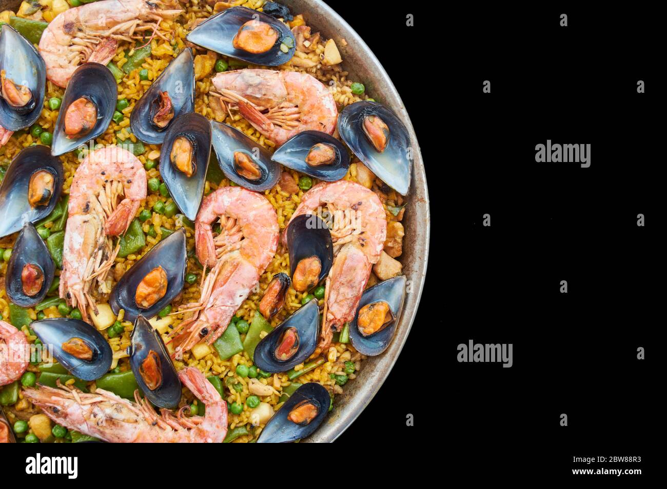 transparency cut, black background, paella typical Spanish food, with seafood vegetable meat, and rice Stock Photo