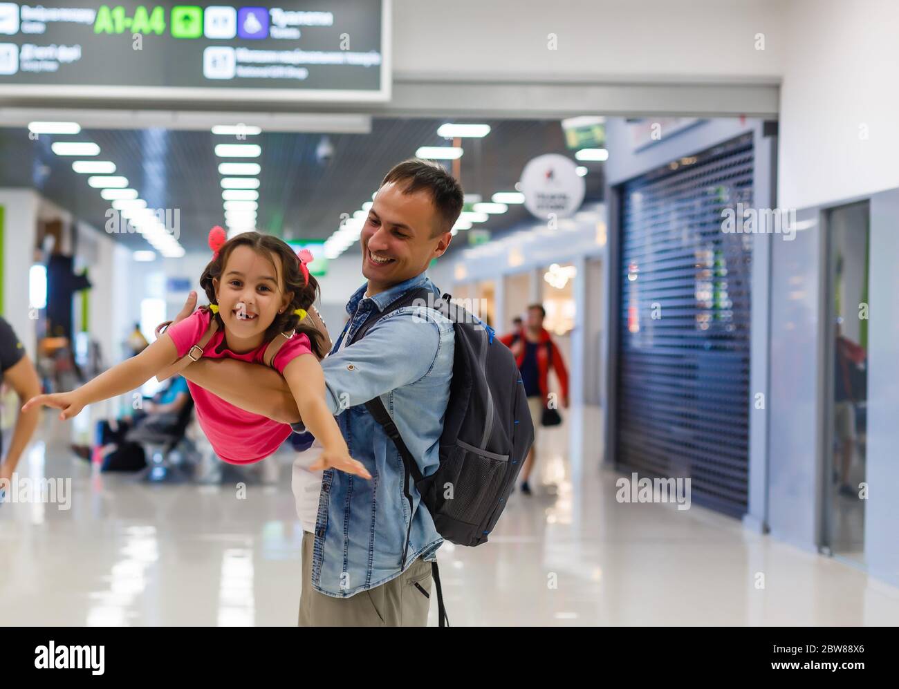 Lets find our flight. view of happy father and daughter at the airport ...