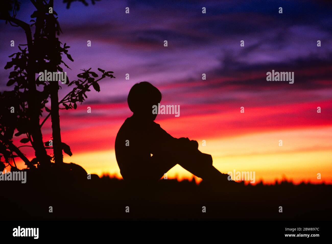 1970s 1980s QUIET BOY CHILD SITTING ALONE ON HILLTOP IN CONTEMPLATION ...