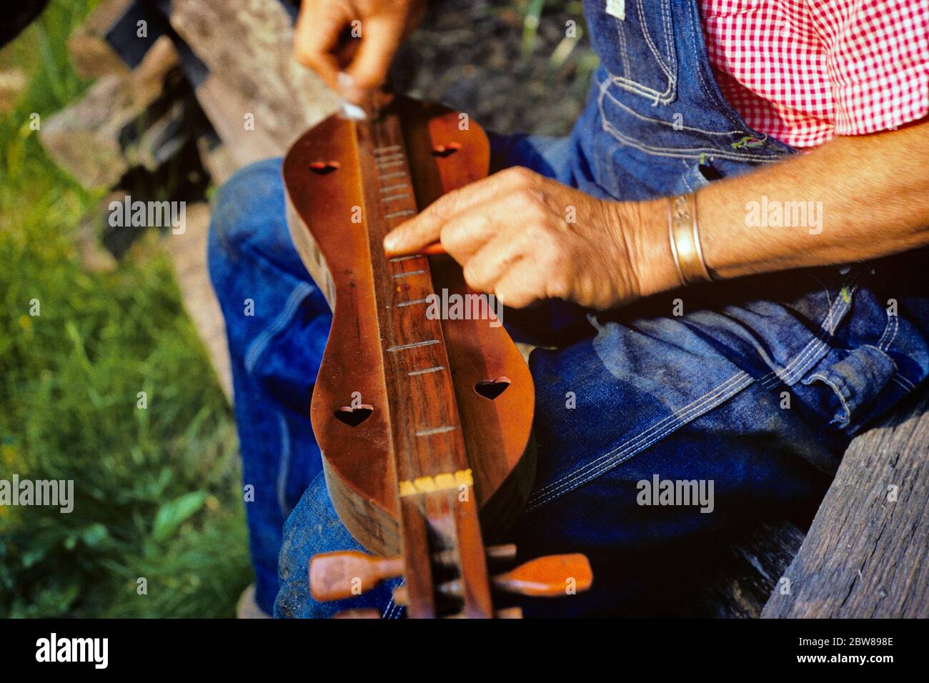 1960s 1970s MAN HANDS PLAYING A MOUNTAIN DULCIMER IN MOUNTAINS IN NC