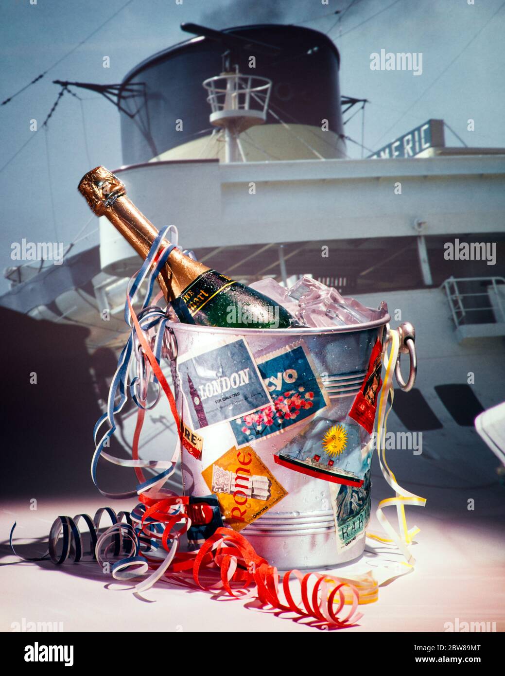 1970s OCEAN LINER STEAM SHIP SAILING DEPARTURE SYMBOLIC STILL LIFE SET-UP UNOPENED CHAMPAGNE BOTTLE ON ICE AND PAPER STREAMERS   - ks8798 PHT001 HARS TRANSPORTATION GOALS COVERED DREAMS HAPPINESS NOURISH ADVENTURE LEISURE SHIPBOARD SMOKEY AND LOW ANGLE RECREATION VOYAGE BON VOYAGE CONCEPTUAL STILL LIFE MOBILITY NOURISHMENT STYLISH SET-UP STEAM SHIP SYMBOLIC CHAMPAGNE BOTTLE CHAMPAGNE BOTTLES OCEAN LINER RELAXATION UNOPENED DEPARTURE OLD FASHIONED Stock Photo