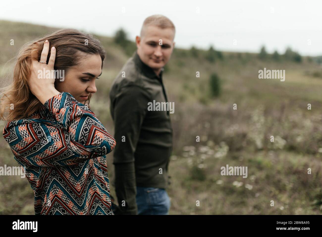 Young woman touching hair with hand when her boyfriend is looking at her. Happy couple Stock Photo
