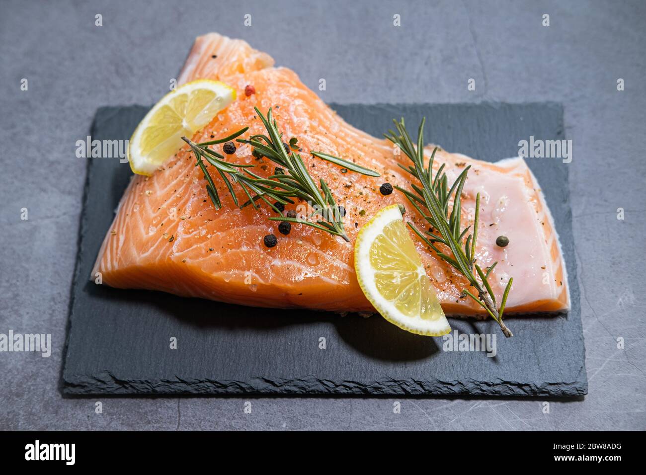 Fresh raw salmon on slate plate and concrete background Stock Photo - Alamy