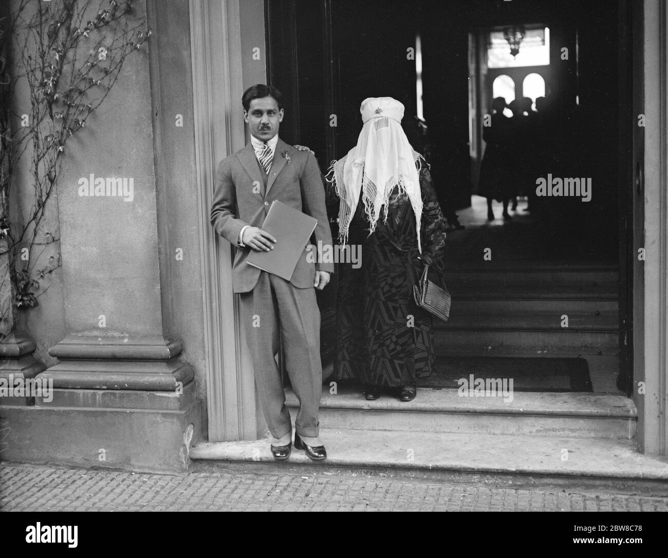 Begum of Bhopal leaves for India after abdicating in favour of her son . The Begum of Bhopal with the new ruler at the door of Belmont House , Parkside , Wimbledon , just before their departure . 19 May 1926 Stock Photo