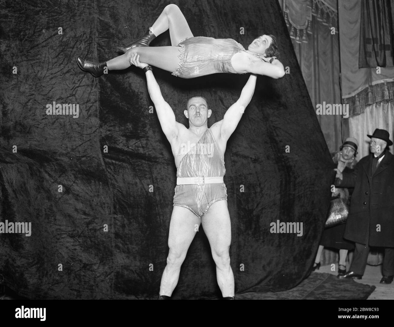 How to support a wife . Herman Gorner , who claims to be the world ' s strongest man , in England challenging the world in contests of pure strength . Corner gives a demonstration by lifting his wife above his head . 22 April 1927 Stock Photo