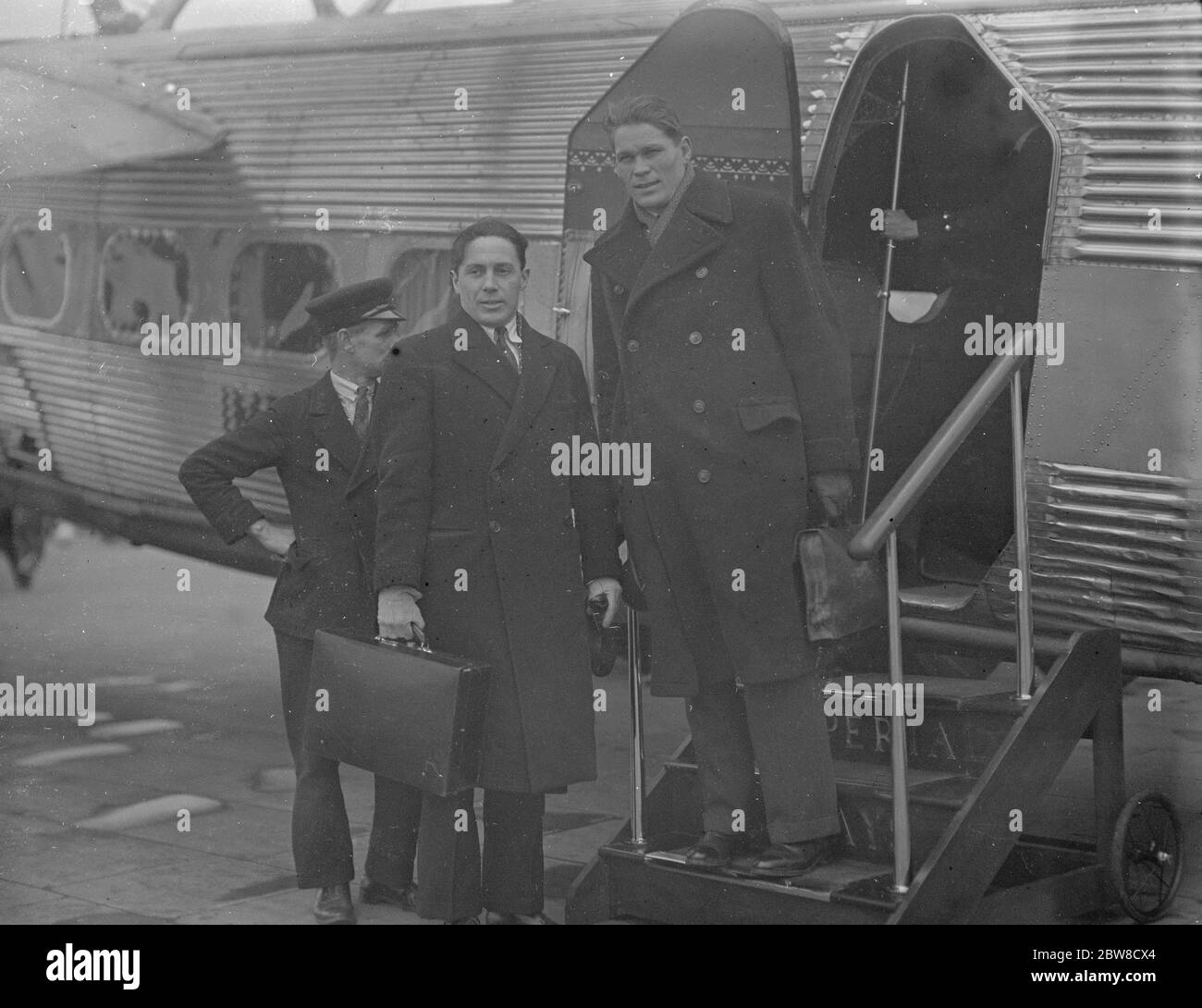 Next Thursday ' s big fight at the Albert Hall . Mr Dickson flies to Croydon with opponent originally chosen for Peterson . Mr Dickson on arrival with Guhring by aeroplane on Sunday , Guhring will now fight Petersen instead of Spakow . 19 February 1933 Stock Photo