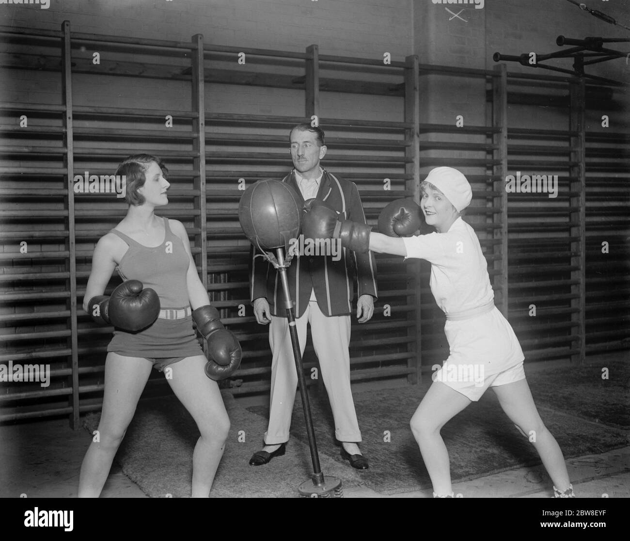 England ' s popular young film star at the Mayfair Gymnasium . Miss Flora le Breton ( right ) at the punch ball . 31 January 1930 Stock Photo