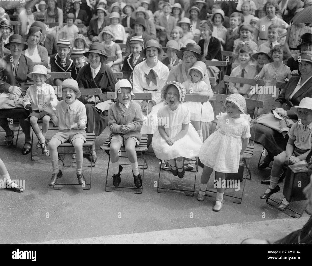 Childrens Garden party to aid clinic . A children ' s Garden party in aid of the Duchess of York ' s Maternity Clinic of the Royal Free Hospital , took place at the Duke of York ' s Headquarters , Chelsea. Some of the very interested spectators of a conjuror ' s tricks . 22 June 1932 Stock Photo