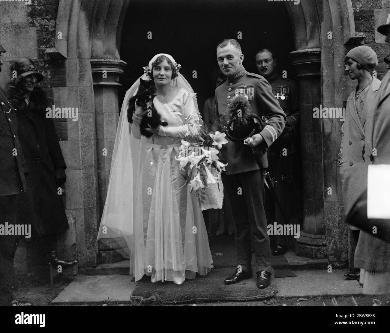 Distinguished airman and his bride fly off together after village church wedding . The bride and bridegroom after the ceremony . Miss Phyllis Bletsoe , the adopted daughter of Mr and Mrs Harold Brown of Sywell House , Northants and Squad Leader G H Martingell , AFC , RAF , were married at Sywell Parish Church . 16 September 1930 Stock Photo