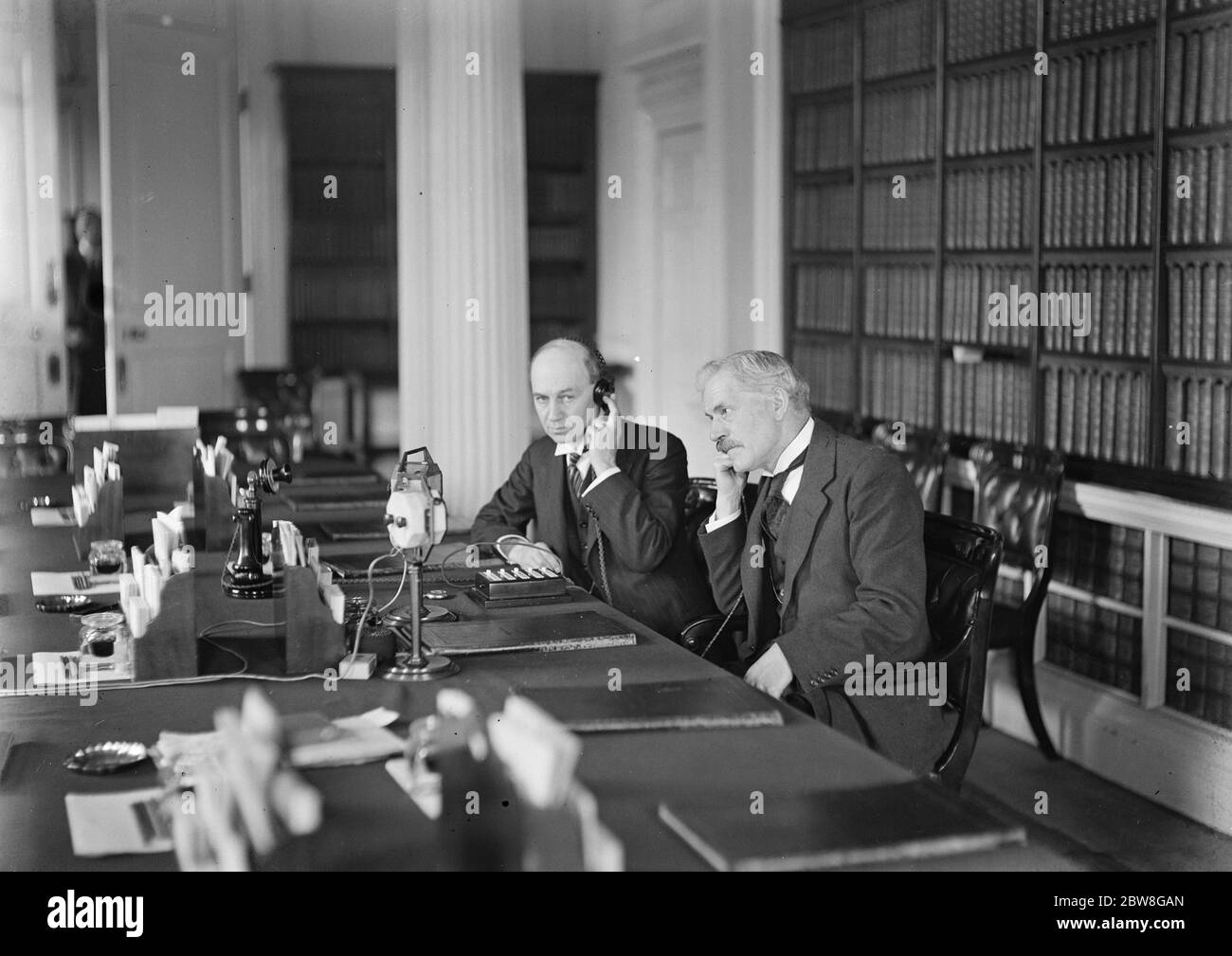 Wireless phone service to Australia . Mr Ramsay MacDonald sitting in the Cabinet room at 10 Downing street , conversed by telephone with Mr Scullin , the Australian Premier at Canberra . With him is the postmaster . 30 April 1930 Stock Photo