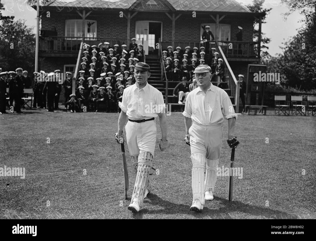Team of Admirals play cricket match against Nautical College , Pangbourne . Rear Admiral Lewin ( wearing glasses ) and Vice Admiral A G Hotham coming out to open the batting for the Admirals Team . 13 June 1931 Stock Photo