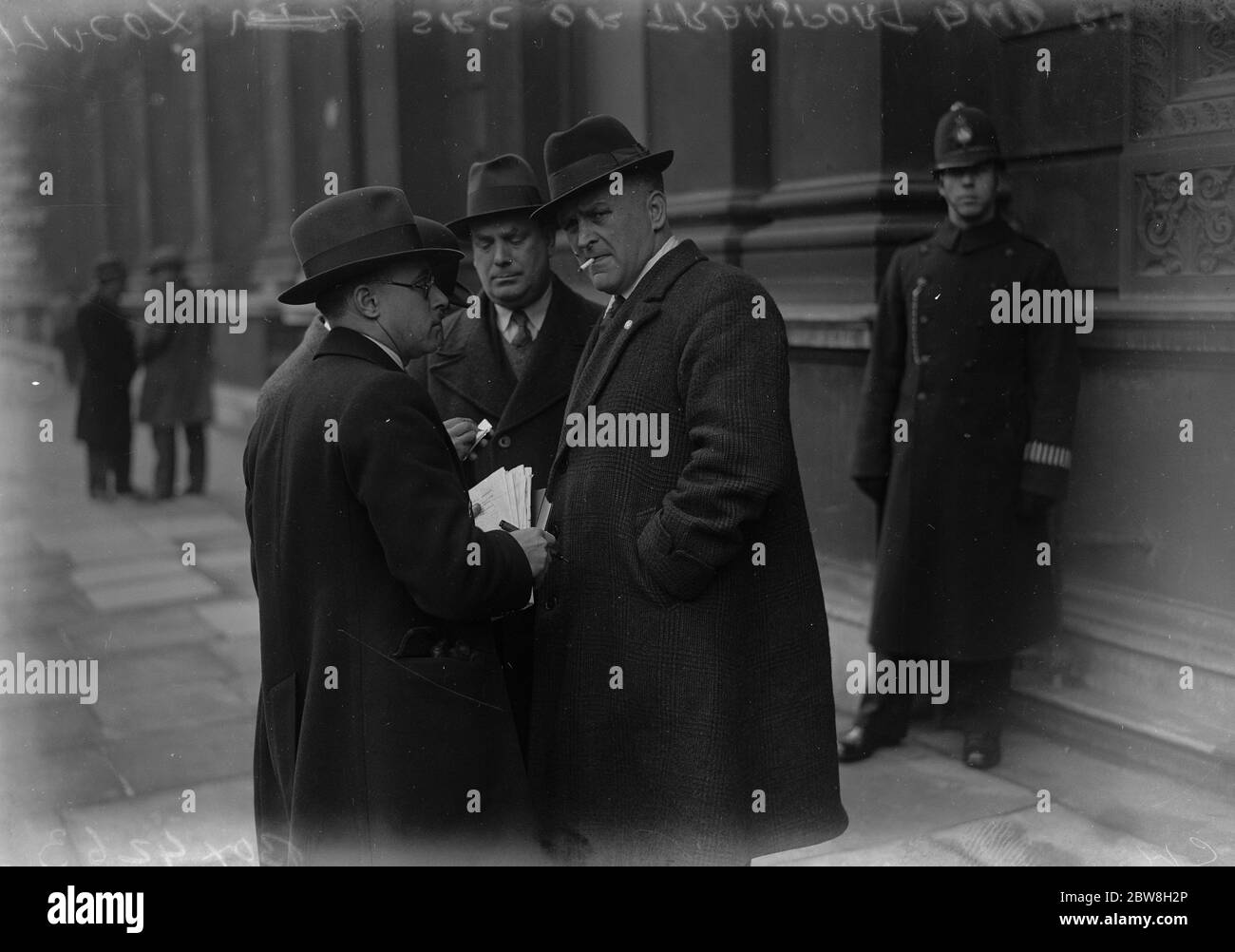 Taxi drivers deputation to the Home Secretary . Mr Cox ( right ) who headed the deputation , discussing the position outside the Home Office . 2 March 1933 Stock Photo