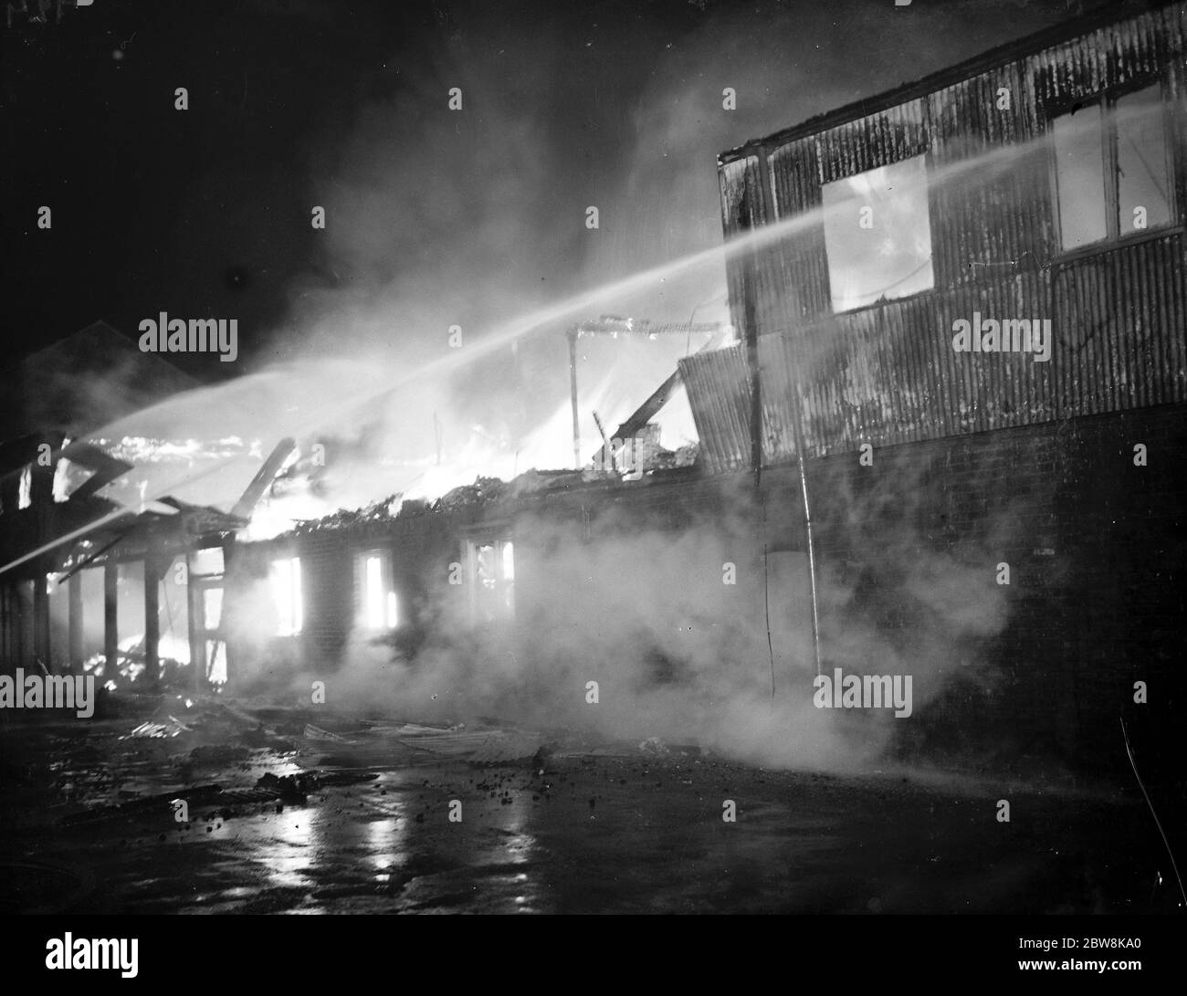 Fire , Halls , Dartford . Fire hoses being trained on the burning building . 1937 Stock Photo