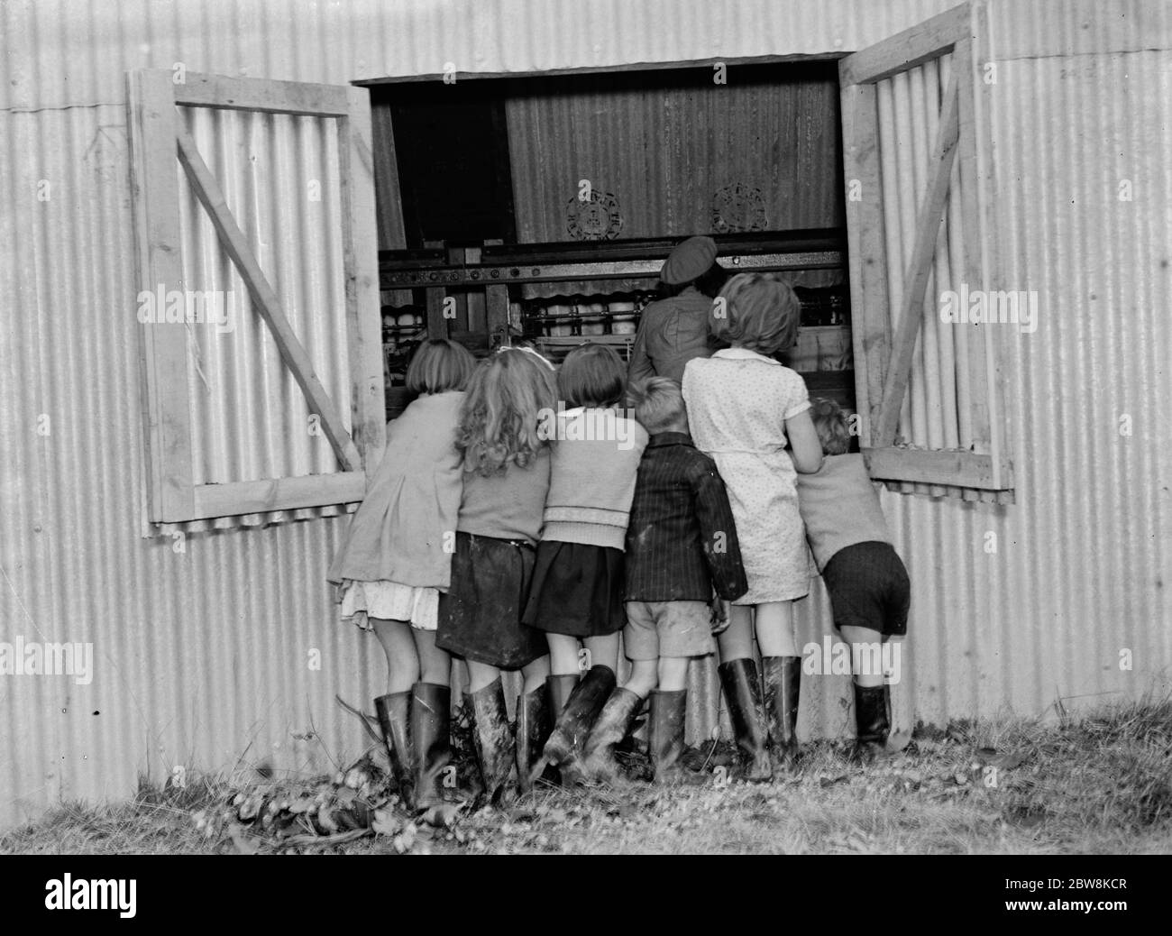 McConnel hinds , children watch the hop picking machine . 1937 . Stock Photo