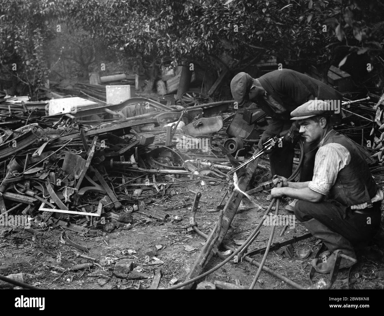 Workmen clearing up metal dumped in an orchard in St Mary Cray , Kent . 22 September 1937 Stock Photo