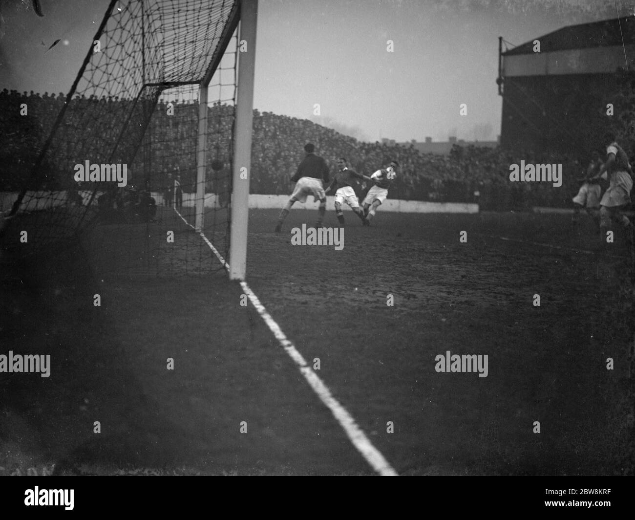 Charlton Athletic football club versus Cardiff City football club . The goalkeeper watches as an attacker shoots at goal . 1938 Stock Photo