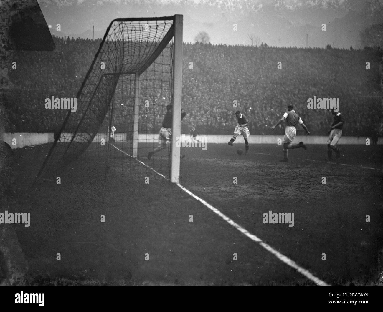Charlton Athletic football club versus Cardiff City football club . The goalkeeper watches as an attacker shoots the ball at the goal . 1938 Stock Photo