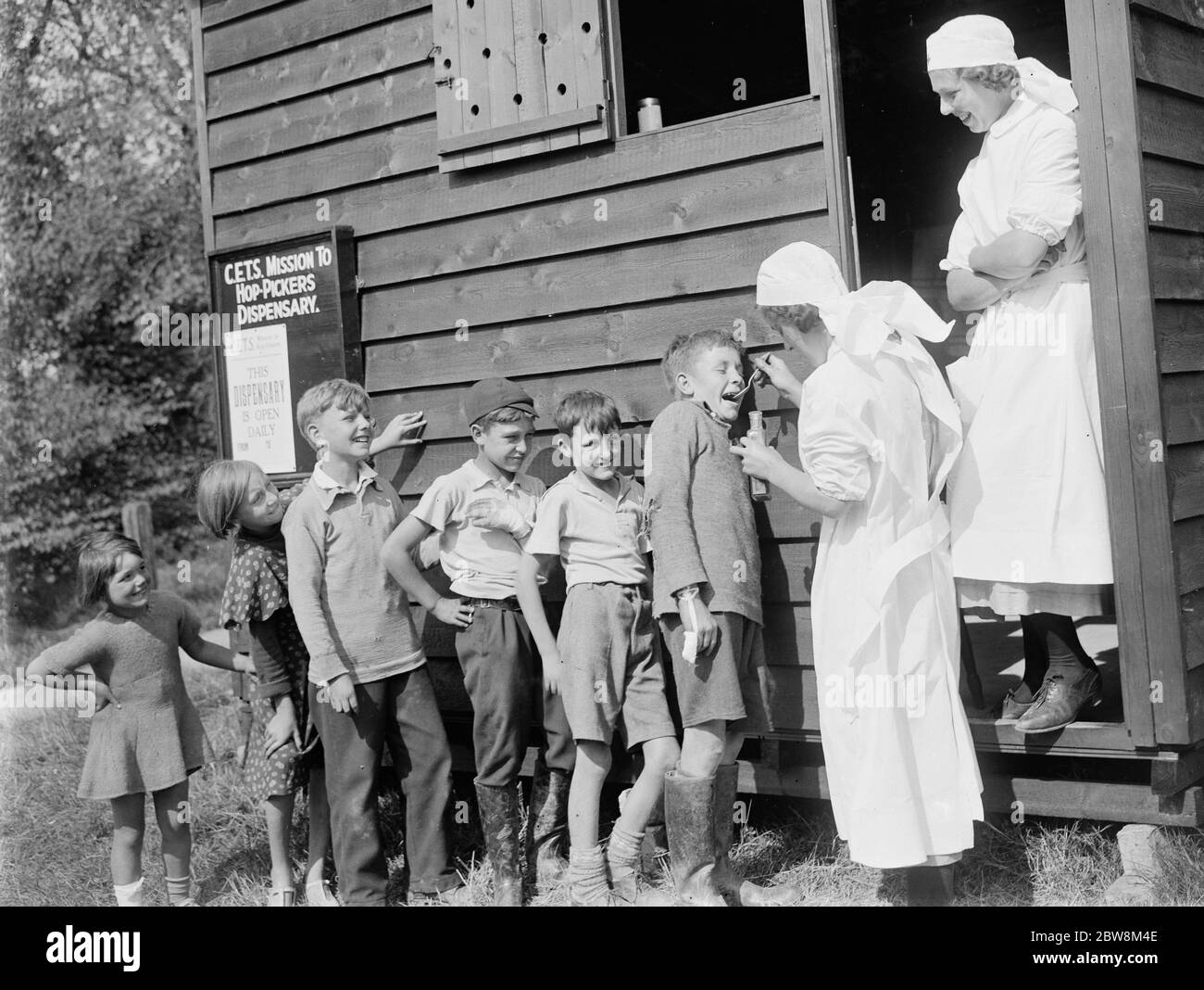 Hop - pickers dispensary , children receiving medicine . 1935 Stock Photo
