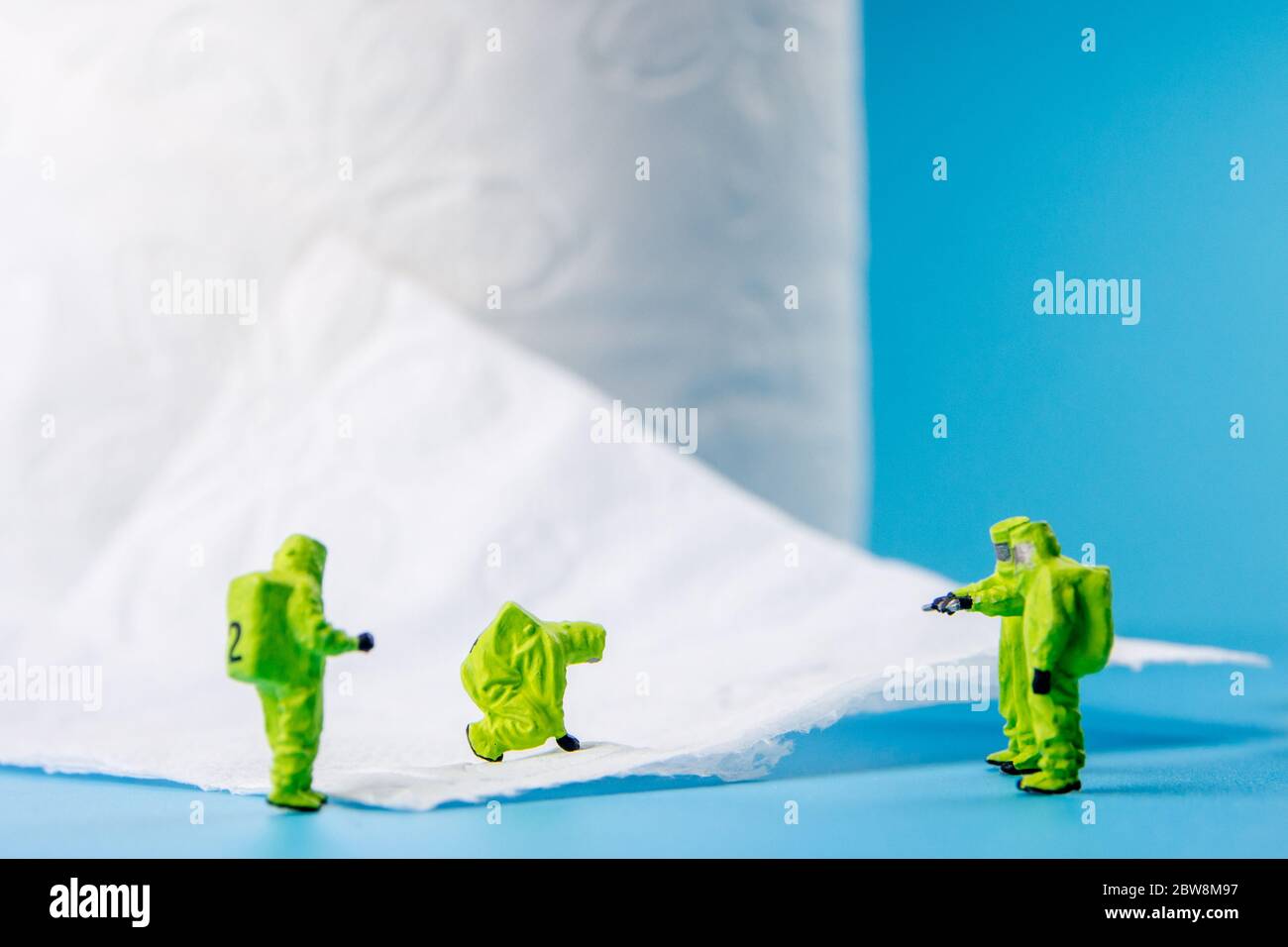 a team of miniature figurines checking a cleanliness of toilet paper, very important to make a desinfection of lavatory and other possibly dirty place Stock Photo