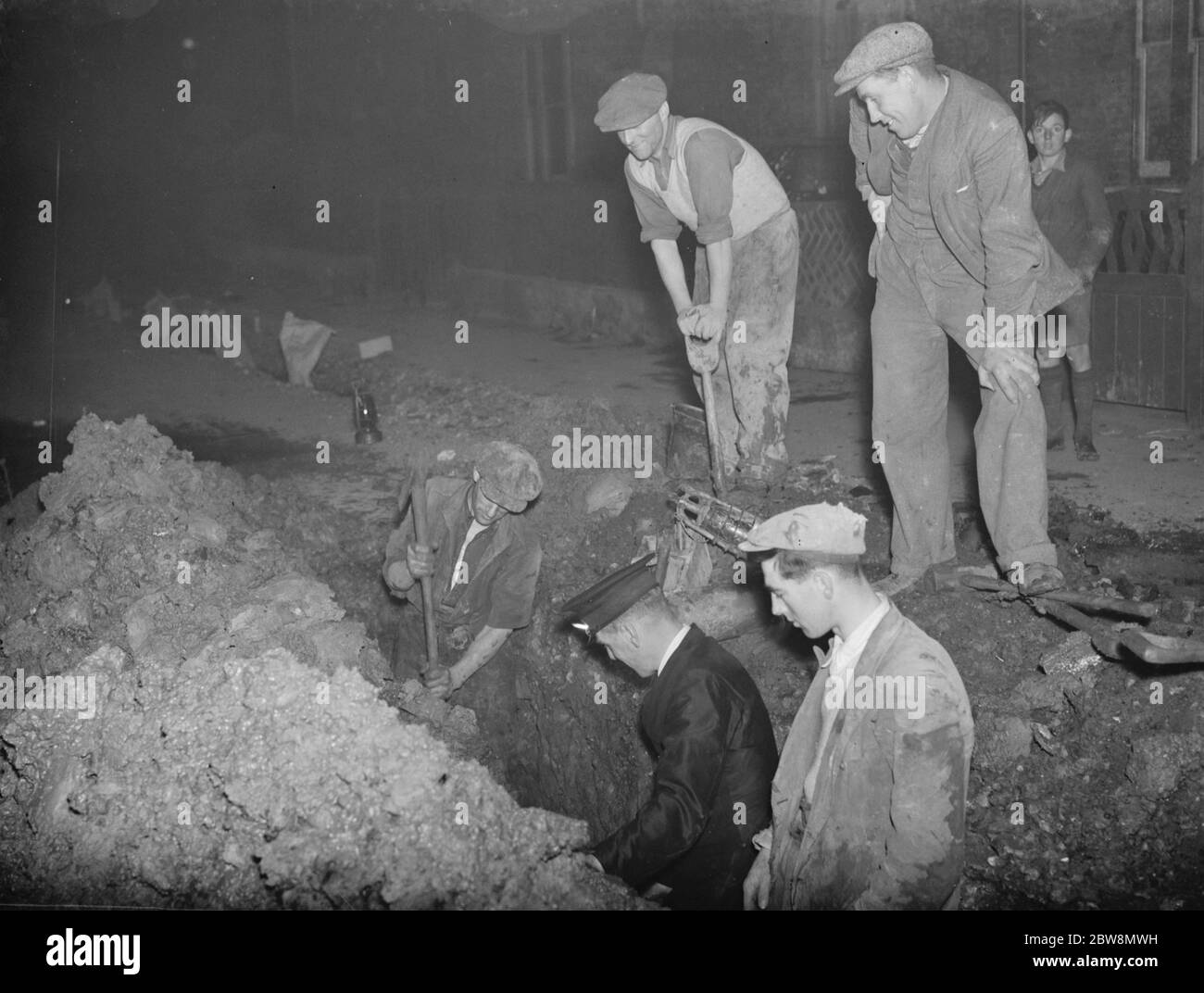 Workmen digging a trench to find the leak in the water main after a burst pipe in Days Lane , Sidcup . 15 October 1937 Stock Photo