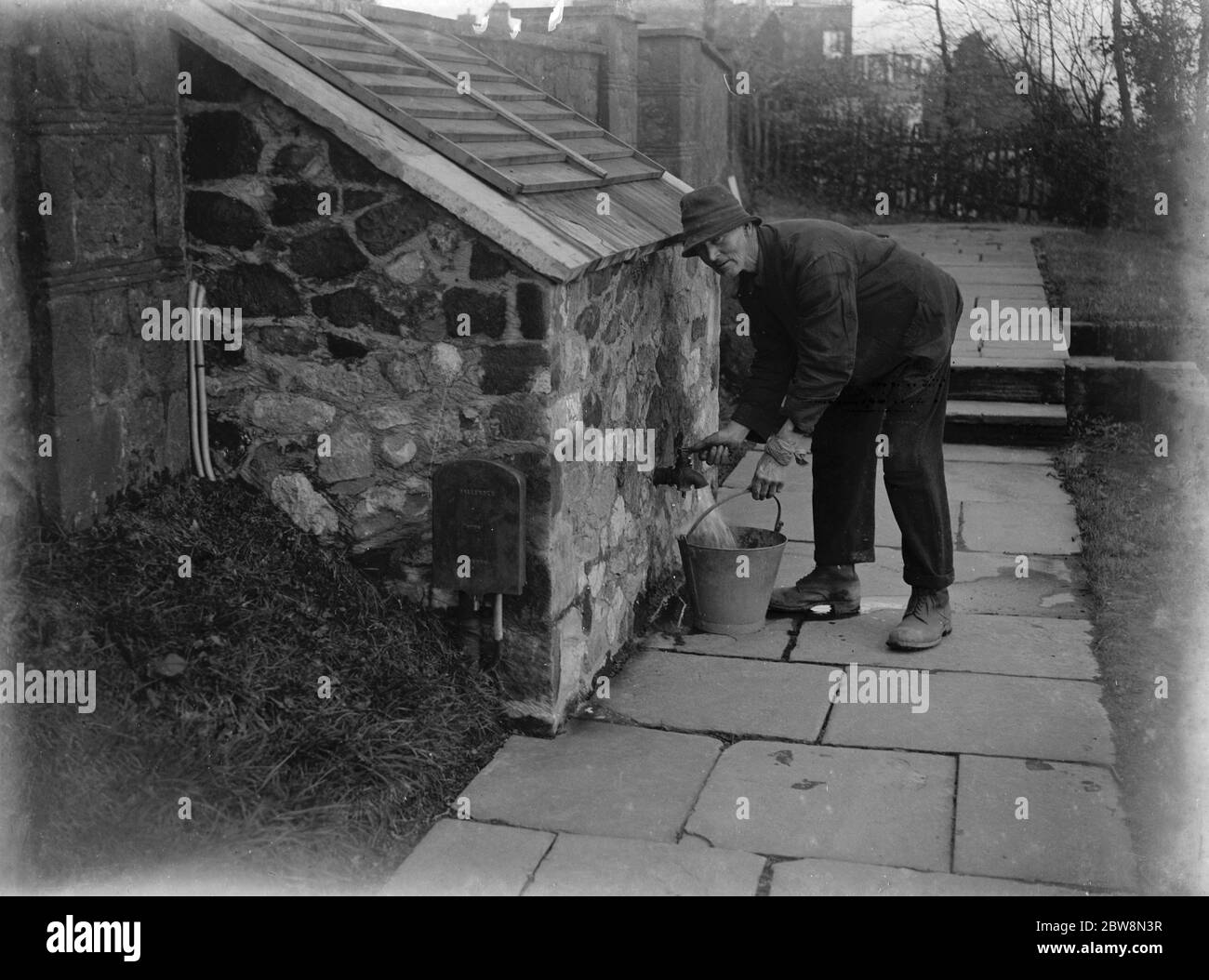 A gardener using an electric powered water pump . Weald , Kent . 1935 Stock Photo