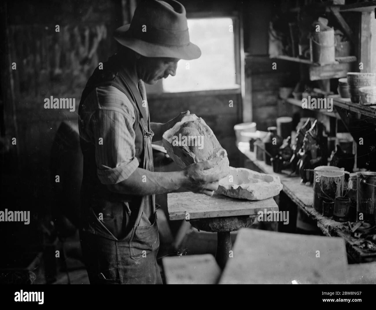 Pottery maker Mr Sadler filling sides of a rabbit mould with clay . 1938 Stock Photo