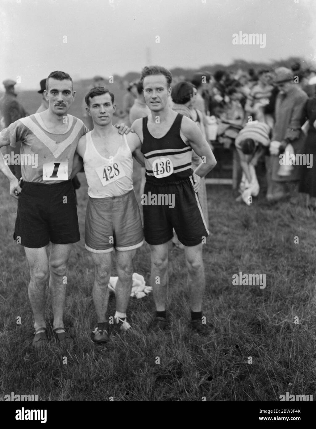 Athletes compete in the Southern Thames cross country race ; They are H H Isted ( No 428 ) , S H Shirley ( No 1 ) R G Gosney ( No 436 ) 1937 . Stock Photo