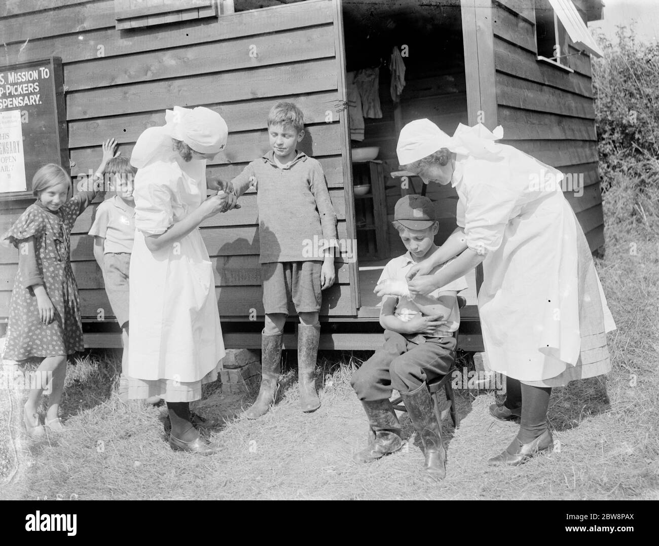 Nurses tending to injured children at the Hop pickers dispensary at Faversham , Kent . 1935 Stock Photo