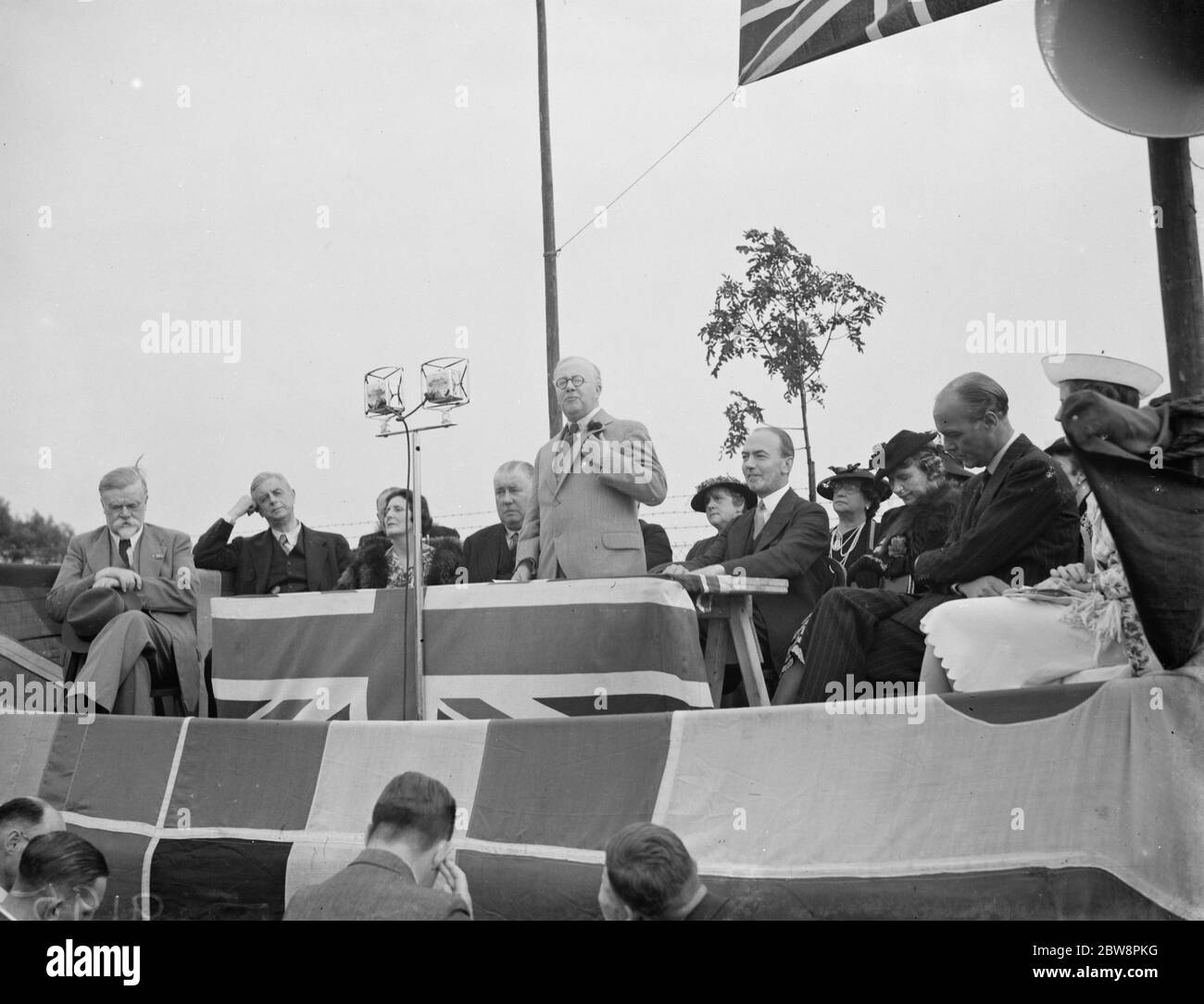 Sir Kingsley Wood giving a speech . To the right is Sir Donald Somervell and Lady Wood . 1938 Stock Photo