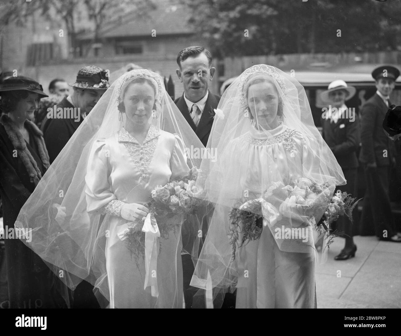 The double wedding of the O ' Brian sisters . The marriages of Mr W T Johnson and Miss A O ' Brian and Mr R H Clark and Miss E O ' Brian . The sisters before their wedding , veils cloaking their faces . July 1938 Stock Photo