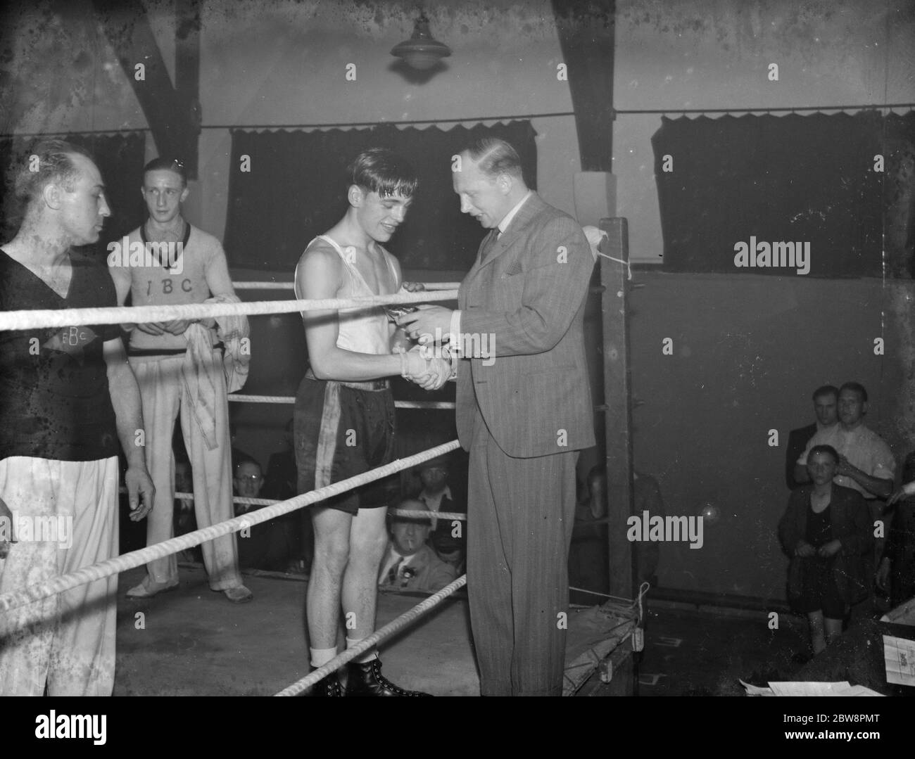 At a boxing tournament in Eltham , Mr Stanley Harris shakes the hand of boxing olympic gold medalist Jackie Fields . 1938 Stock Photo