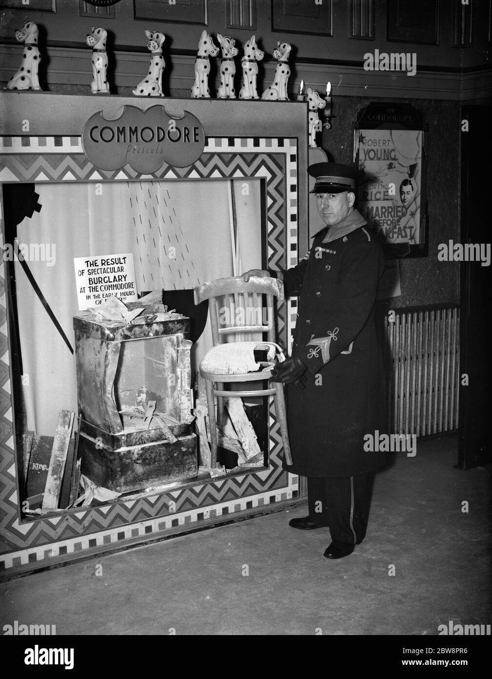 The cinema usher at the Commodore Theatre , Orpington standing by a display of the damaged cinema safe which was blown - up during a burglary . 1937 Stock Photo