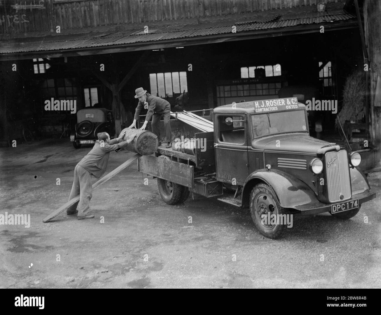 A truck from HJ Rosier & Company being loaded with goods . 1935 Stock Photo