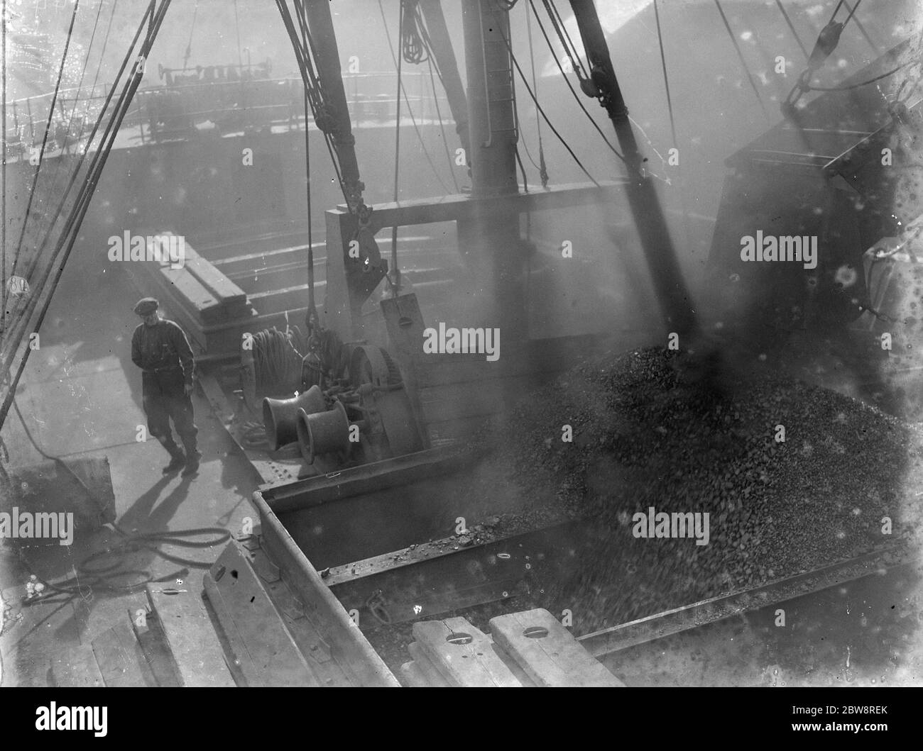 Loading coal into the hold of the tramp steamer the , ' SS Eston ' . 1935 Stock Photo