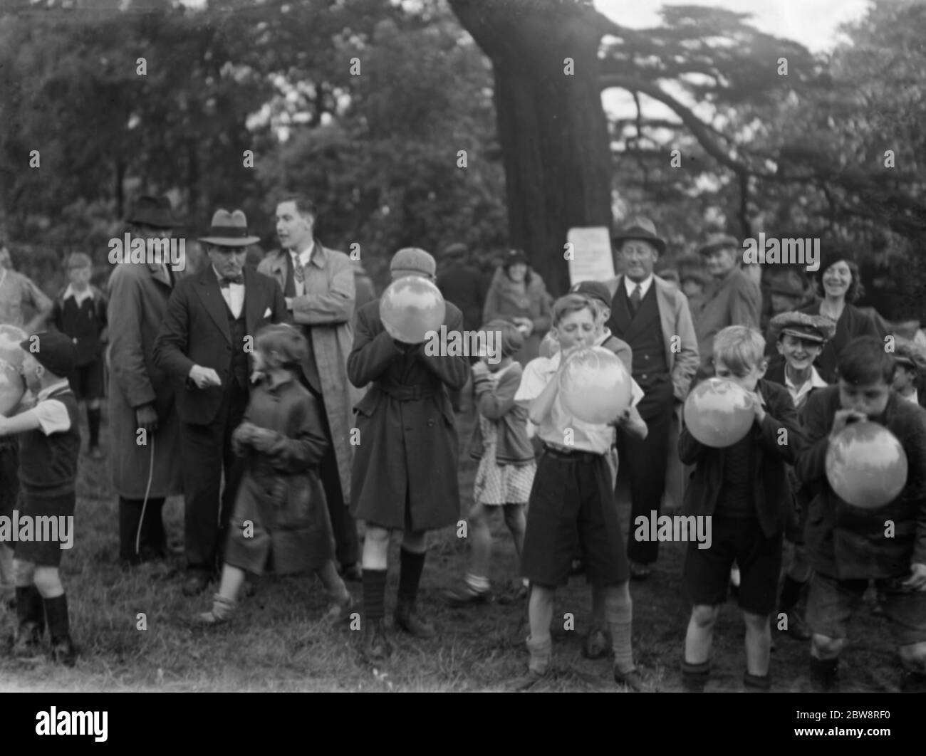 Children bursting balloons at the British Legion fete in Eltham