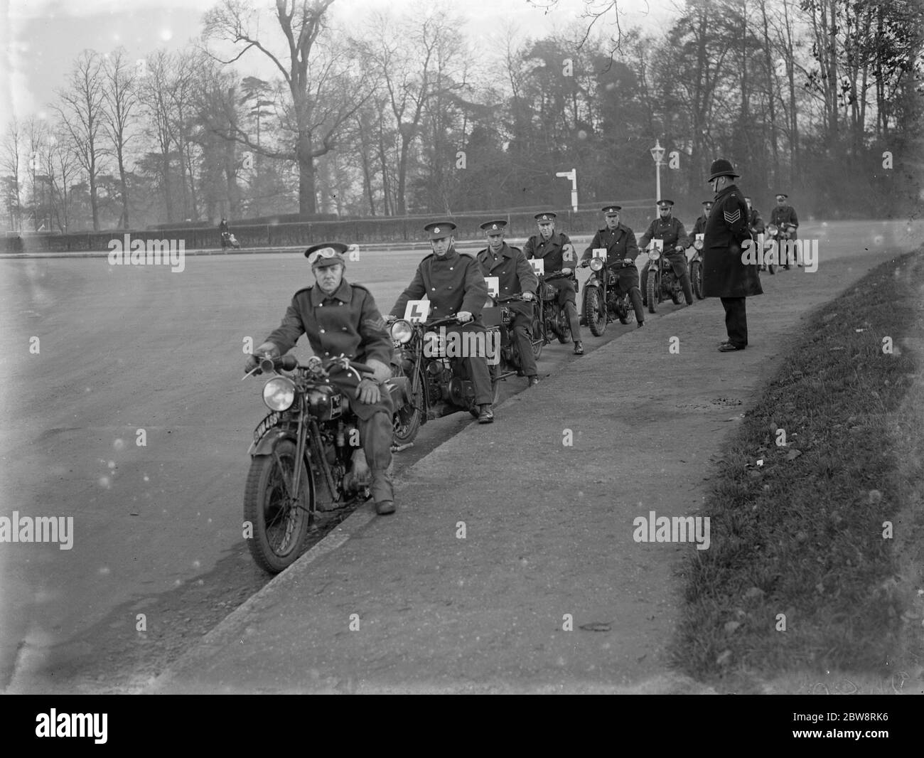 Under the watchful eye of a policeman young soldiers learn to ride motorbikes . 1935 Stock Photo