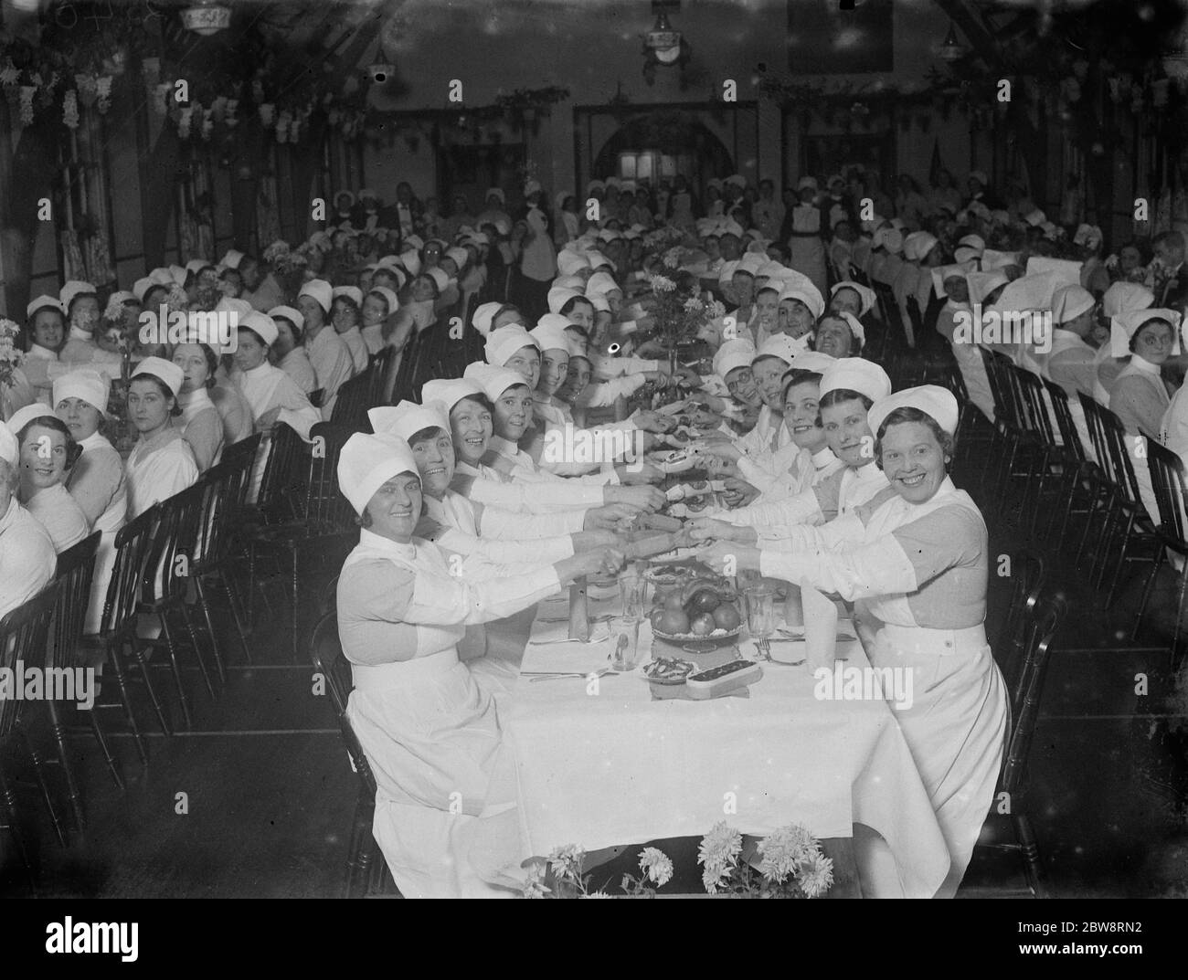 Pulling crackers at the Southern Hospital nurses Christmas dinner . 1935 Stock Photo