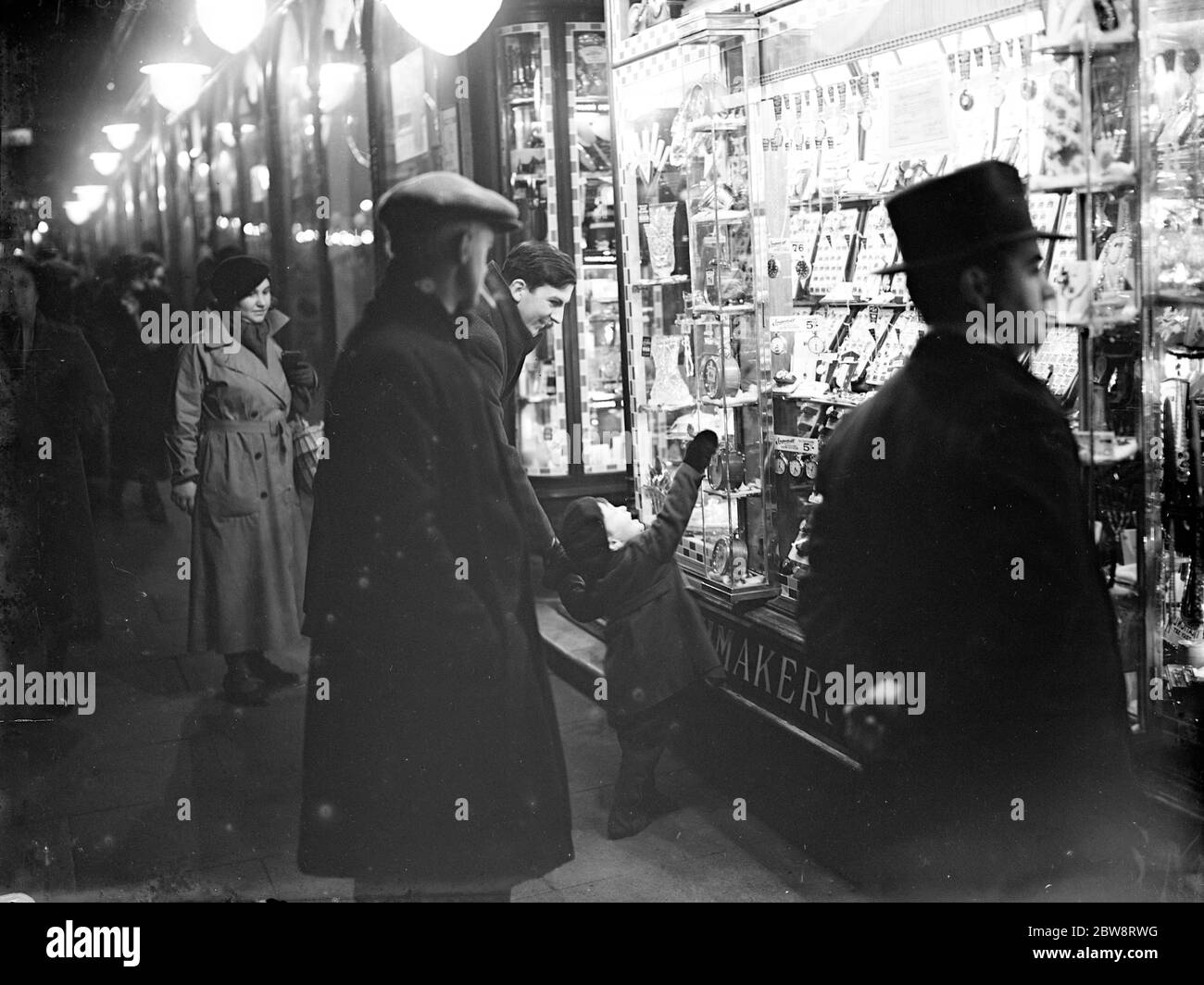 A little boy sees something he wants in a shop window at Christmas time . 1935 Stock Photo