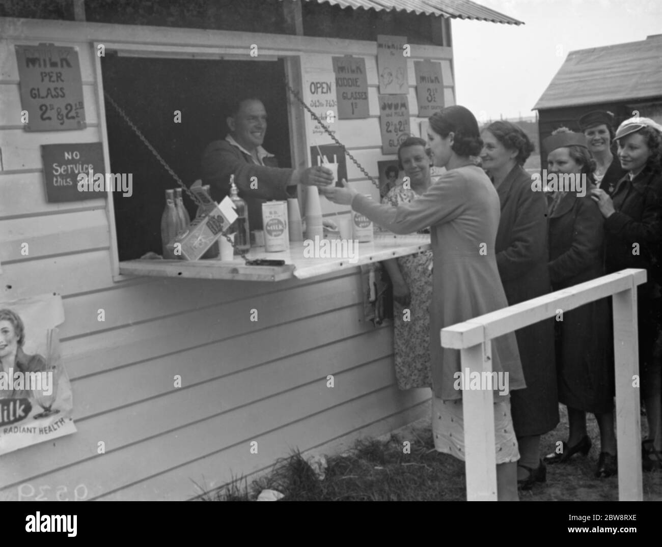Whitbread ' s hop farm in Belting , Kent . People cueing up at the onsite milk bar . 1938 Stock Photo