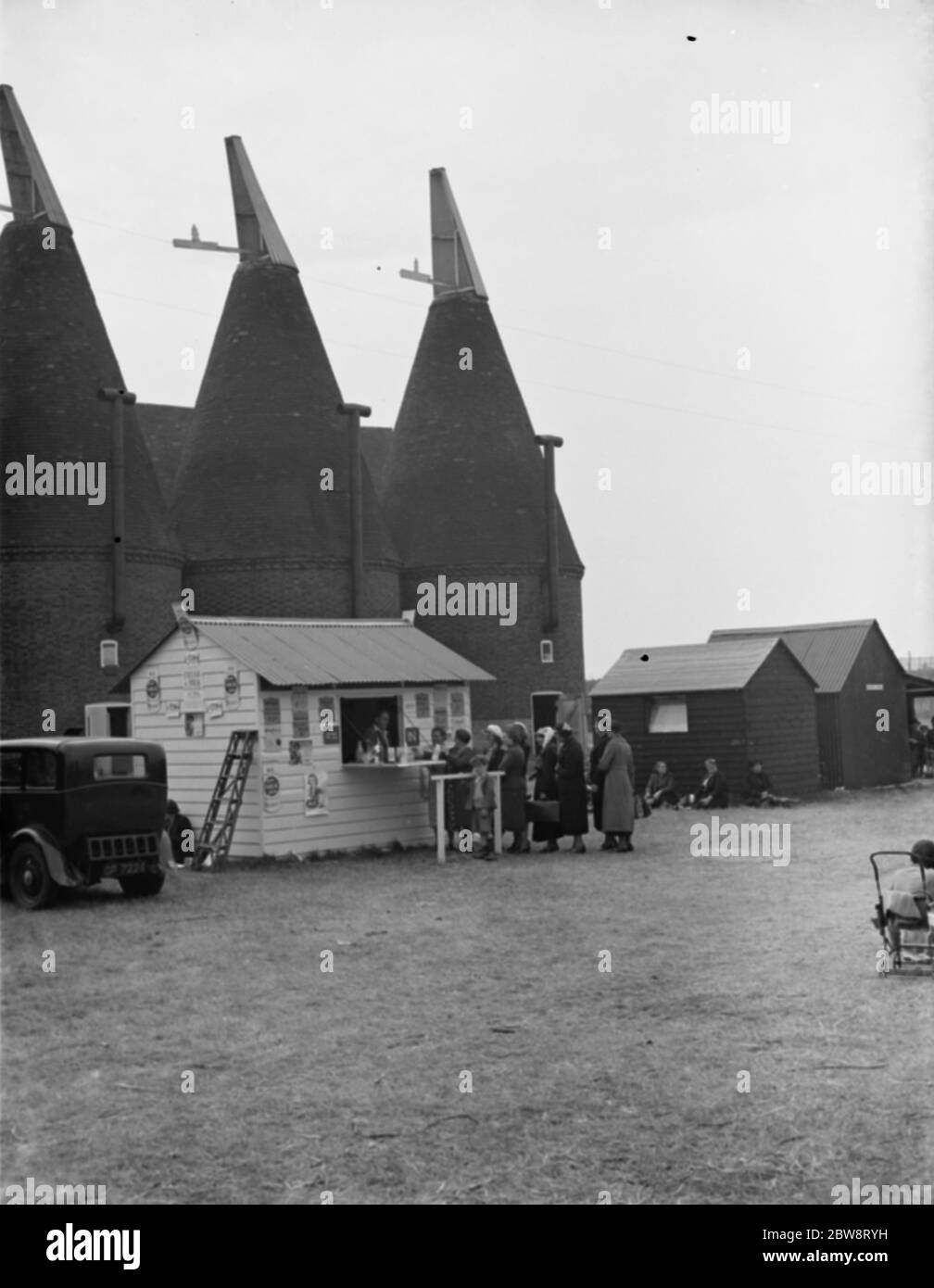 Whitbread ' s hop farm in Belting , Kent . People cueing up at the onsite milk bar . 1938 Stock Photo