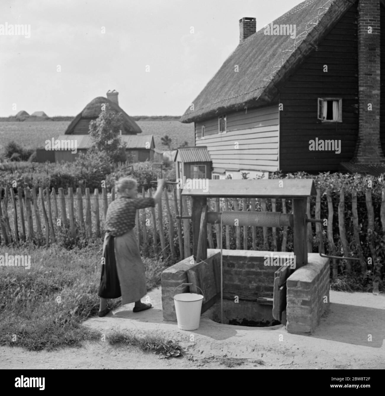 A woman using a water well in Deans Bottom . 1936 . Stock Photo