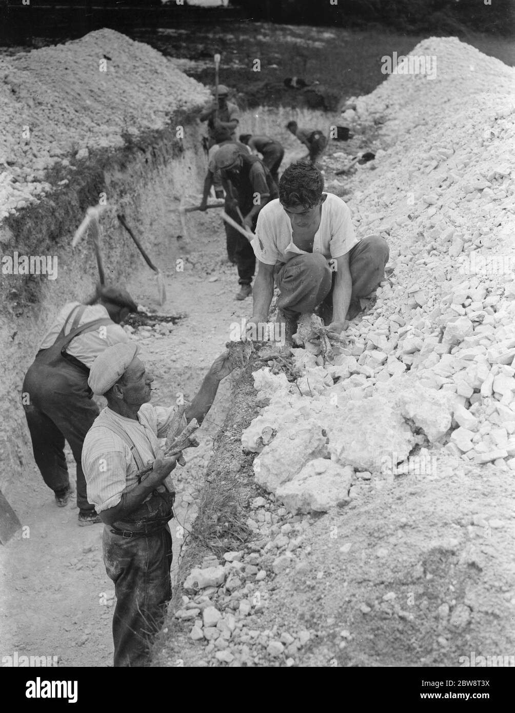 Digging a trench in search for skeletal remains in Horton Kirby , Kent . 1938 Stock Photo