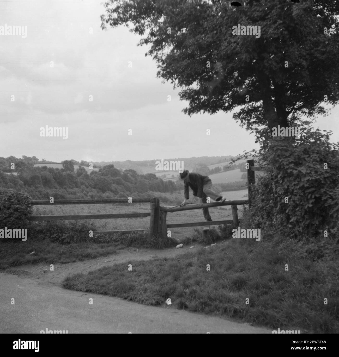 A man crossing a stile in Cudham , Kent . 1936 Stock Photo