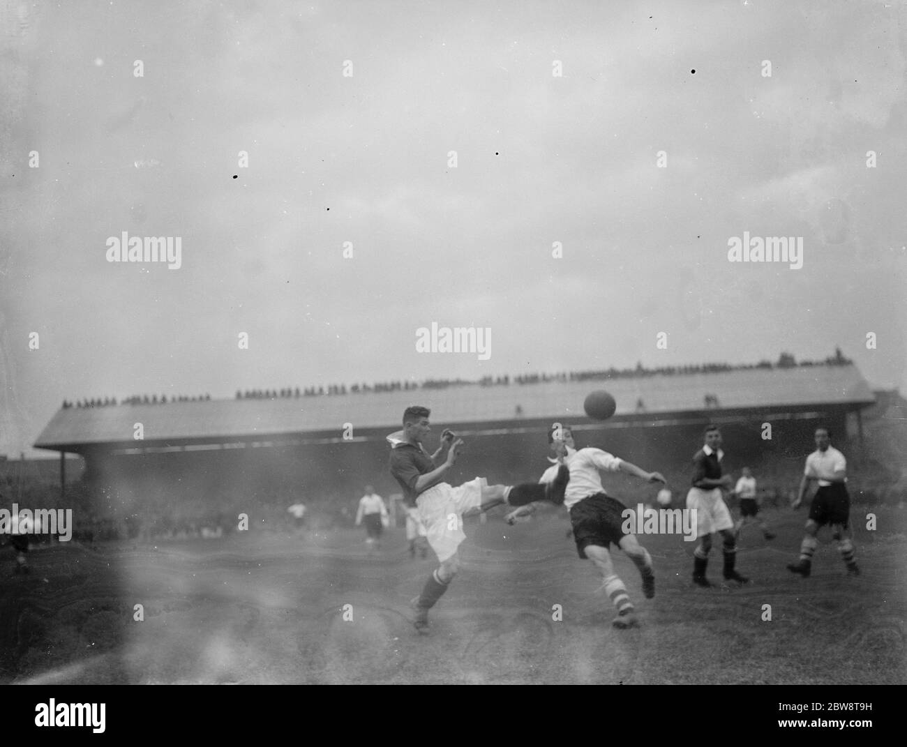 Football match : Arsenal Football Club versus Charlton Athletic Football Club at Highbury Stadium , London . Two players compete for the ball . 1936 Stock Photo