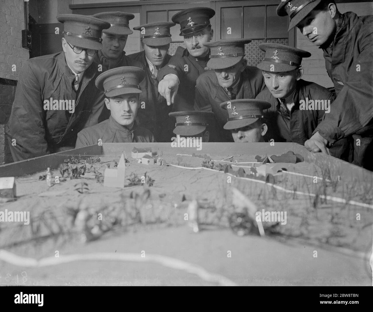 Army officers using a model of terrain for instruction on tactics at the Dartford Territorial Army camp . 1938 Stock Photo