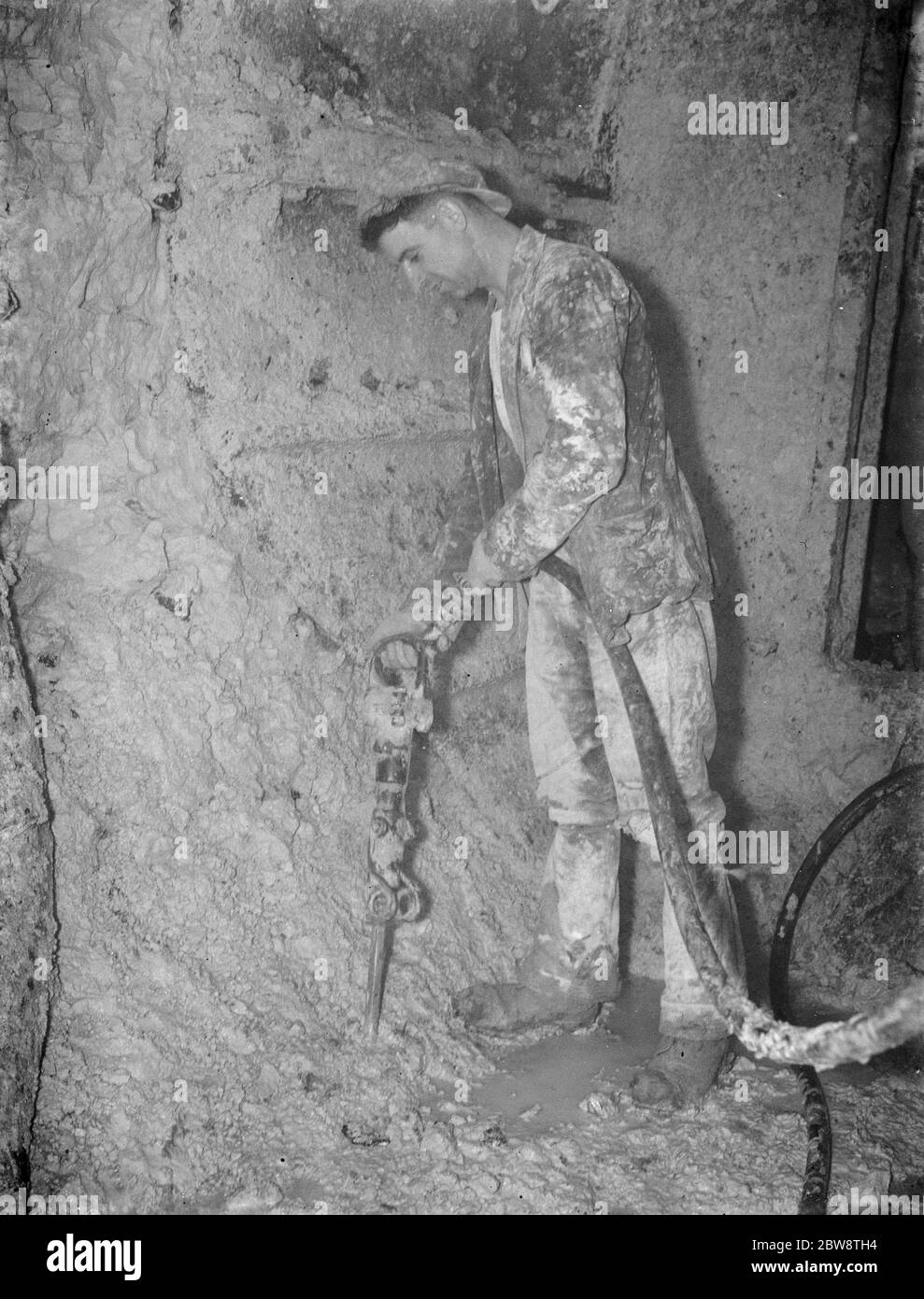 The completion of the pilot Dartford Tunnel . A miner works around a tunneling shield with a pneumatic drill . 11 October 1938 Stock Photo