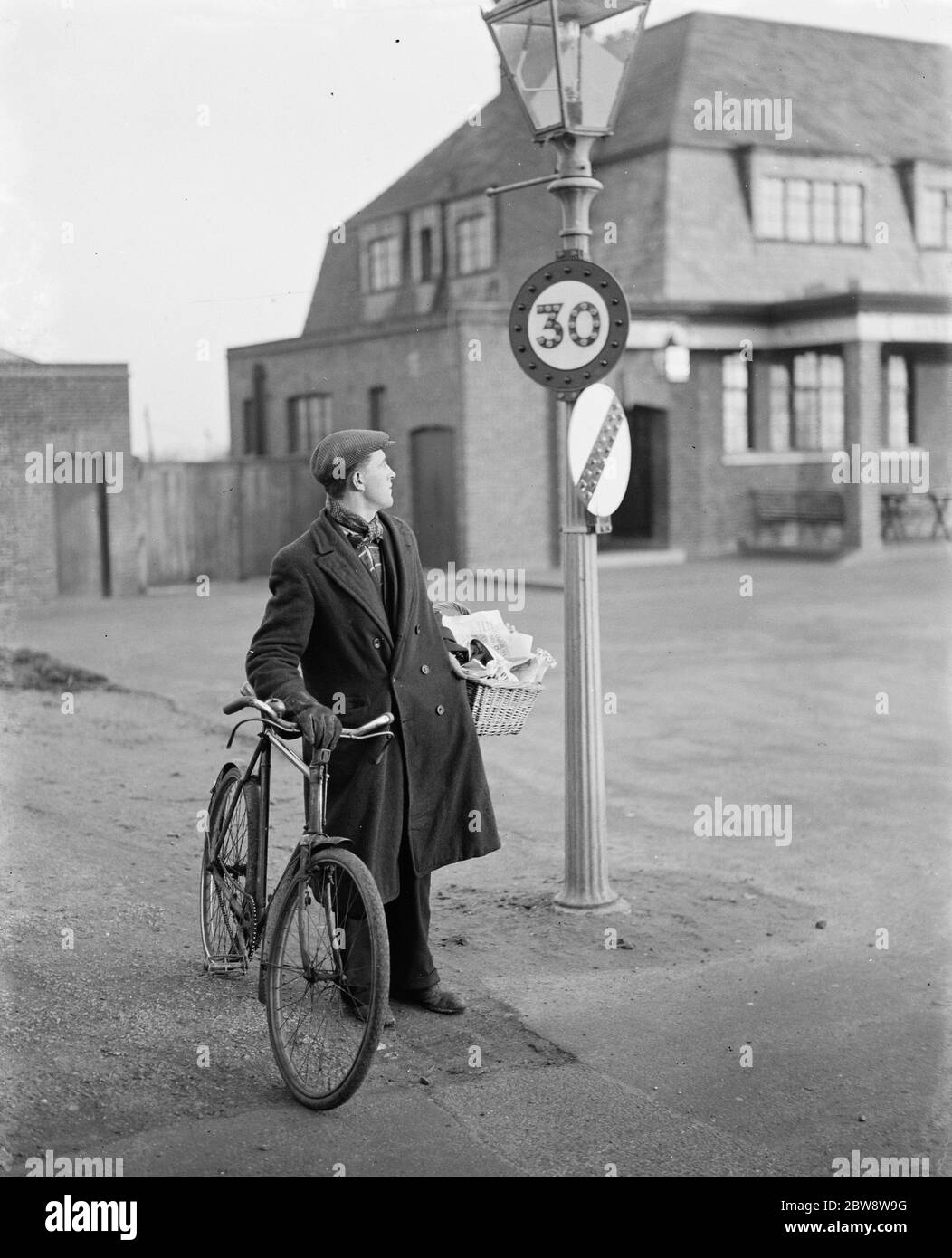 A man looking at a 30 miles per hour speed limit sign in Birchwood , Kent .  1938 Stock Photo - Alamy